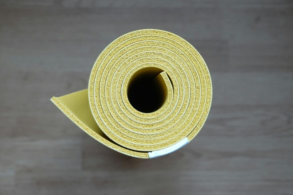  a rolled yellow pilates mat, ideal for busy women for home use